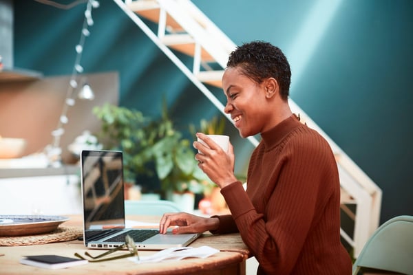 businesswoman at a computer holding a coffee cup