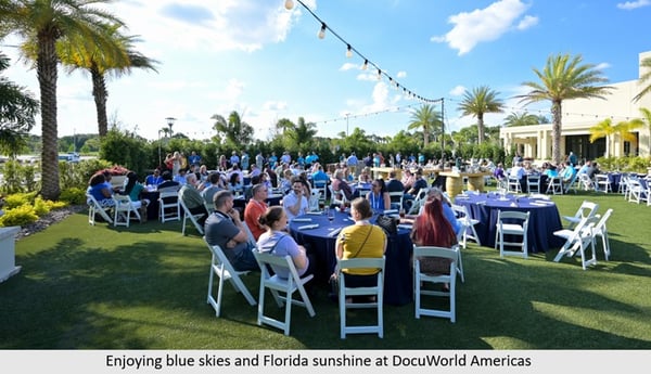 People in white chairs outside sitting at tablesjpg