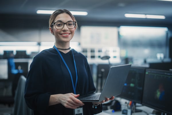 Mujer de negocios sonriendo y sujetando un portátil