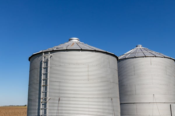 Two gray metal grain silos