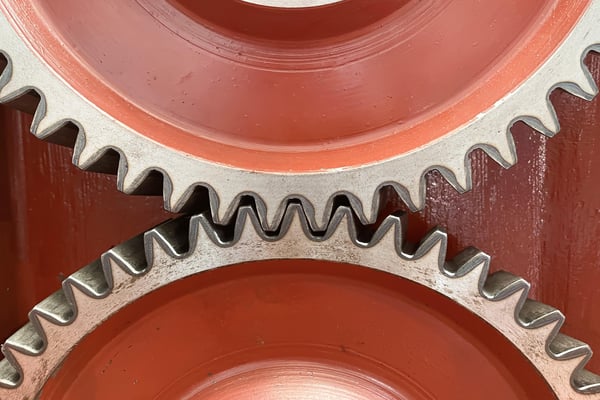 two red and silver gears on a red background 