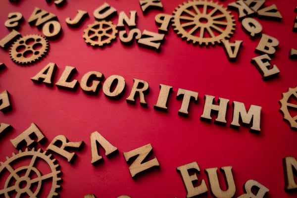 Word algorithm spelled out on wood blocks on a red background