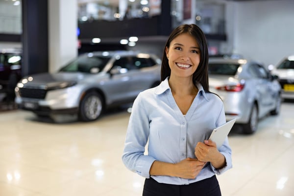 Smiling female auto salesperson in showroom