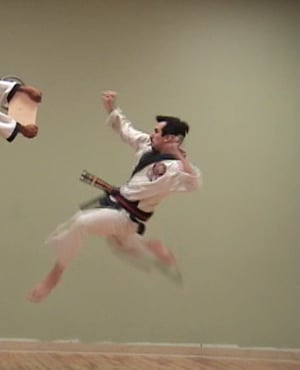 Martial artist performing one legged tornado kick