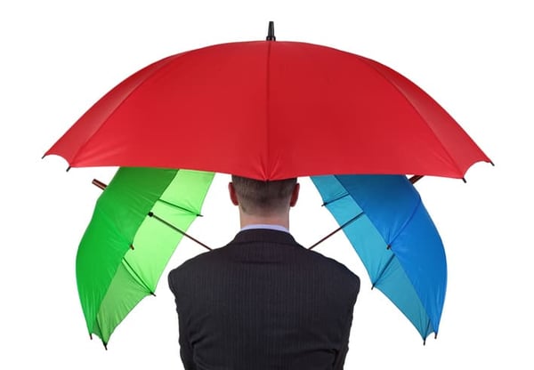 Man protected by three umbrellas