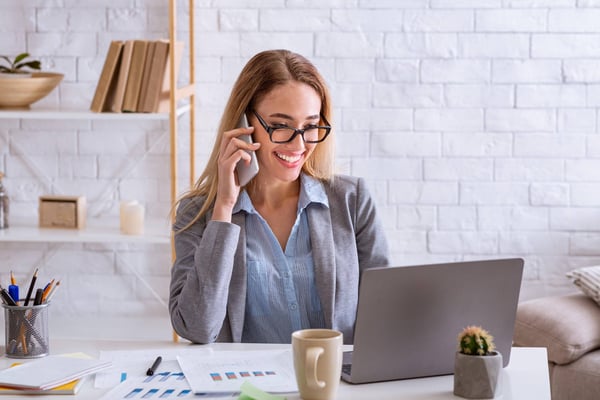 Businesswoman at a computer talking on the telephone