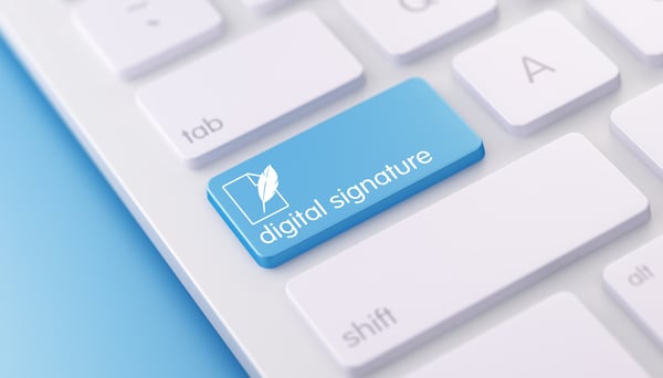 Teclado de ordenador con una tecla azul que dice firma digital