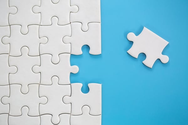 White puzzle pieces on a blue background represents components of organizational development 