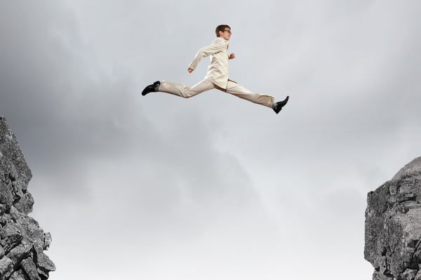 Man jumping from cliff to cliff to show how document management increases innovation