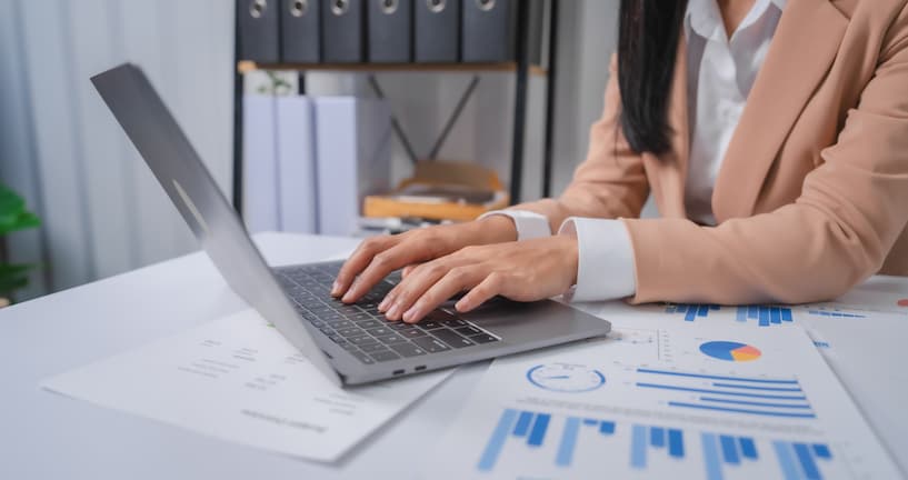 Woman at her desk typing on a laptop