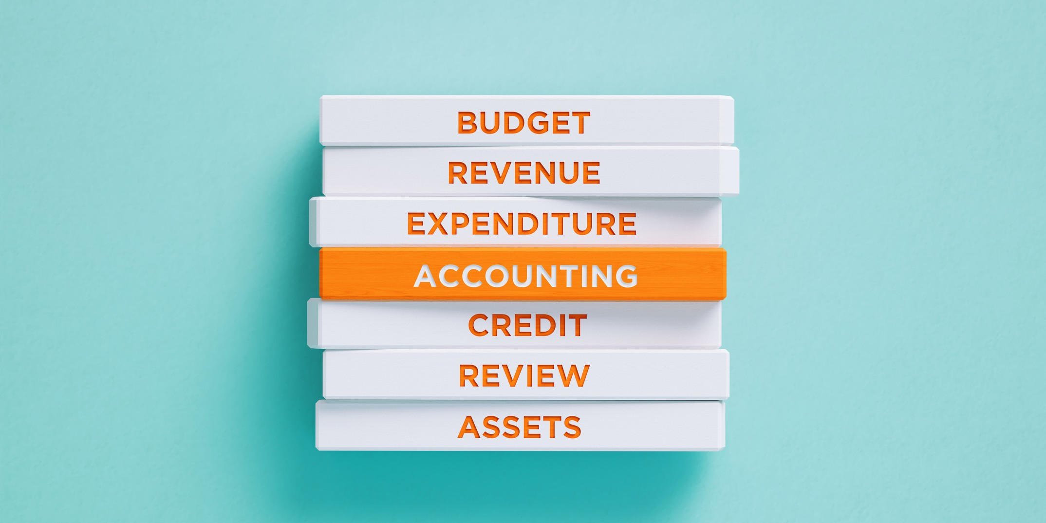 Accounting-related words written on white wood blocks in orange letters on blue background