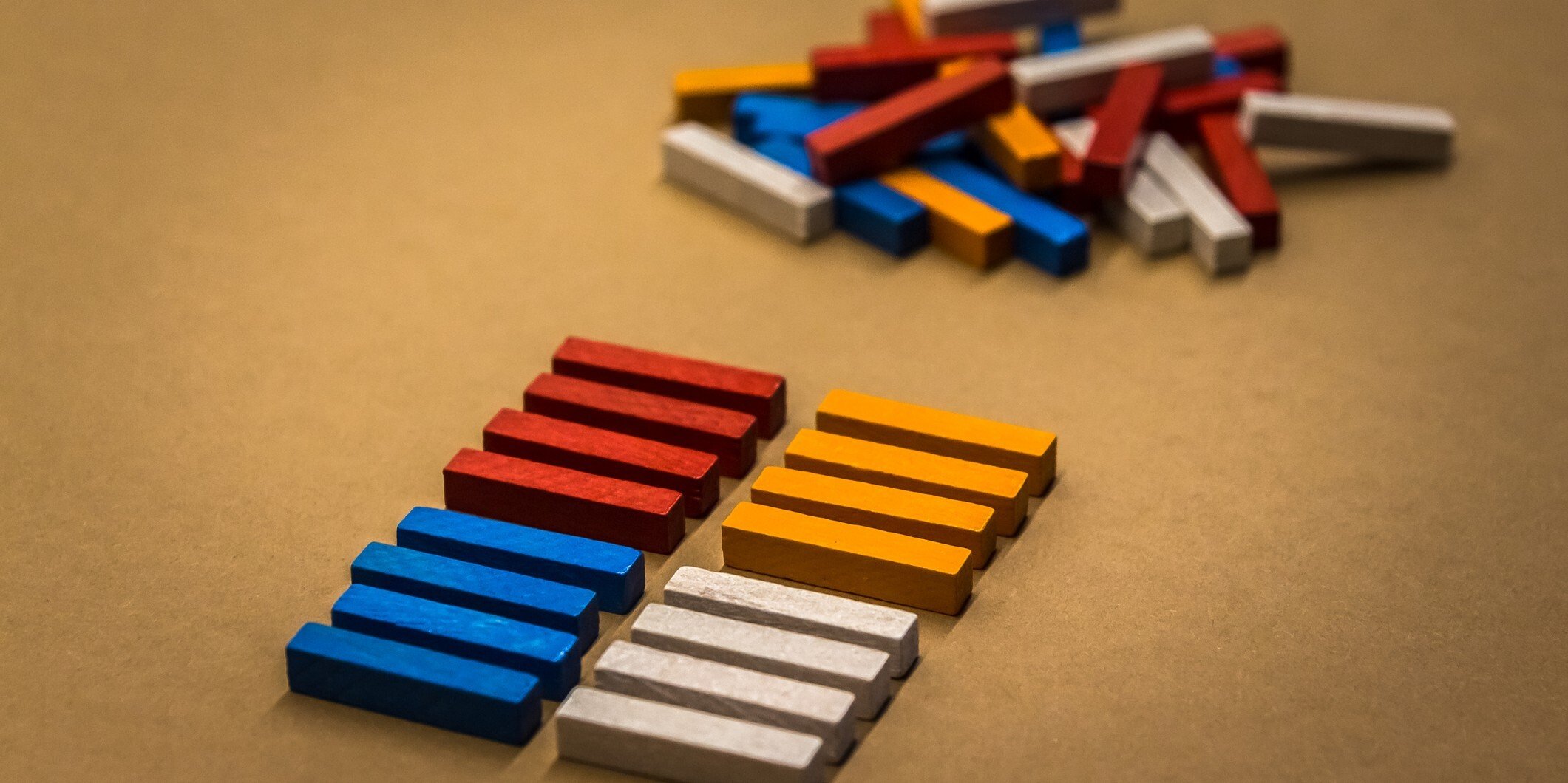 Rectangular, multi-colored blocks lined up in two rows in front of a pile of unorganized blocks