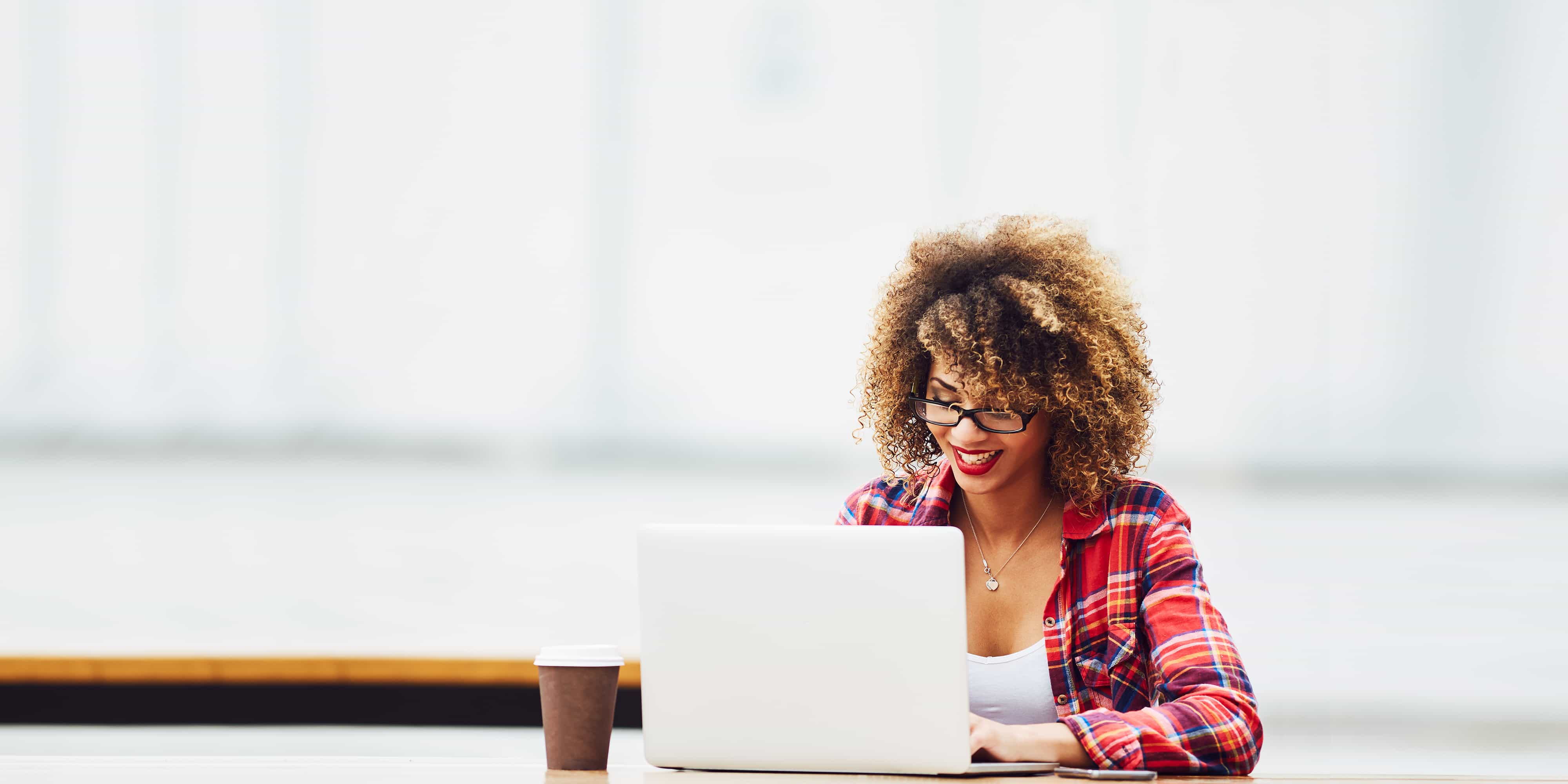 femme en flanelle sur ordinateur portable